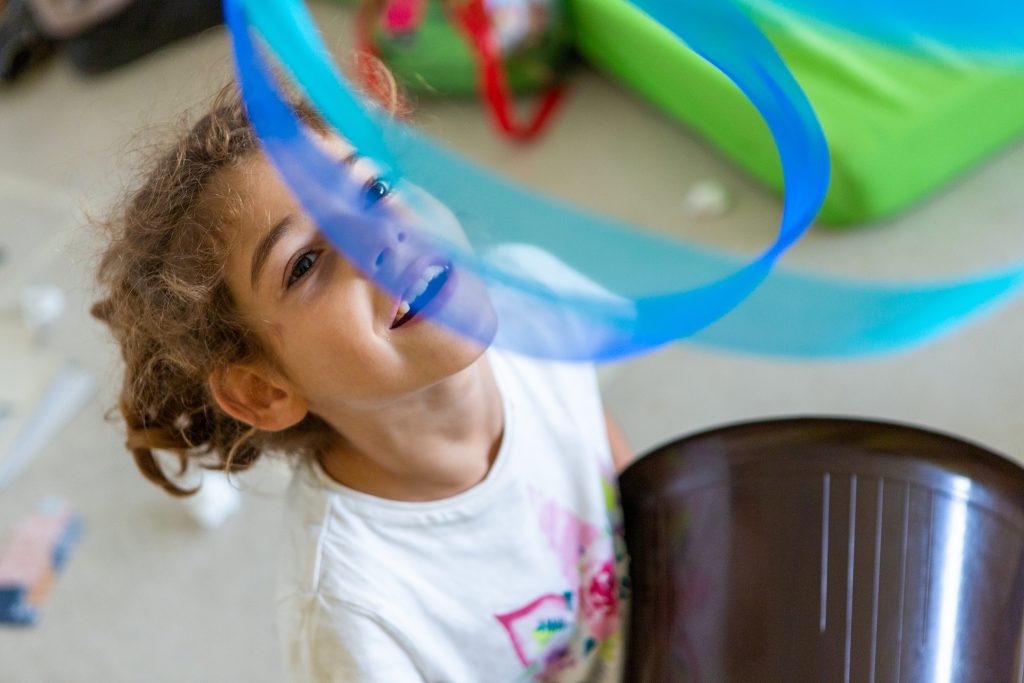 Bambina che gioca con un nastro durante il centro estivo di Contesto.