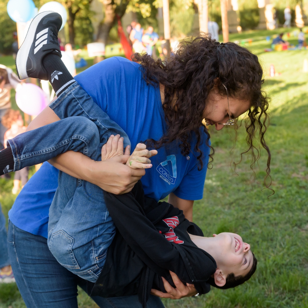 la presidente Giulia gioca con un bambino durante l'open day 2025 di contesto nel prato del parco del castello dell'acciaiolo a scandicci